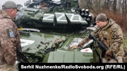 Украинские военнослужащие у поврежденного российского танка Т-72БЗ во время масштабного вторжения России в Украину. Донецкая область, 13 апреля 2022 года