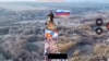 A Russian soldier hoists the Russian flag over Malaya Loknya in the Kursk region.