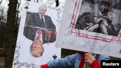 A demonstrator holds signs during a protest outside the US Embassy in Kyiv on March 15. 