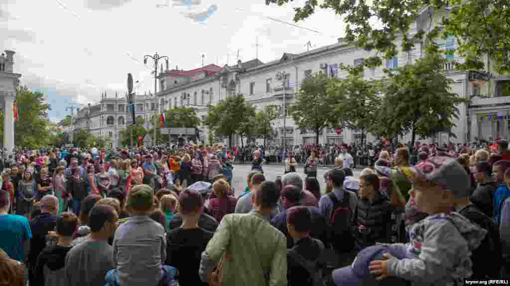 Ранним утром люди собираются в центре города, чтобы посмотреть на парад Вооруженных сил России